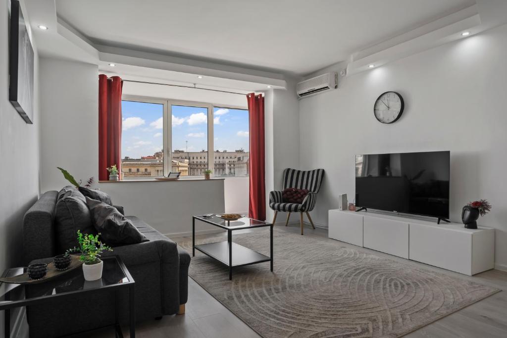 a living room with a couch and a tv at Quiet Apartment Ruby Horizon in Bucharest