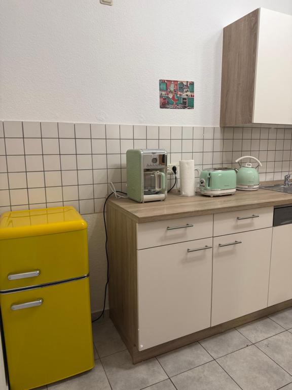 a kitchen with a counter with a yellow trash can at Retro Style in Erfurt in Erfurt