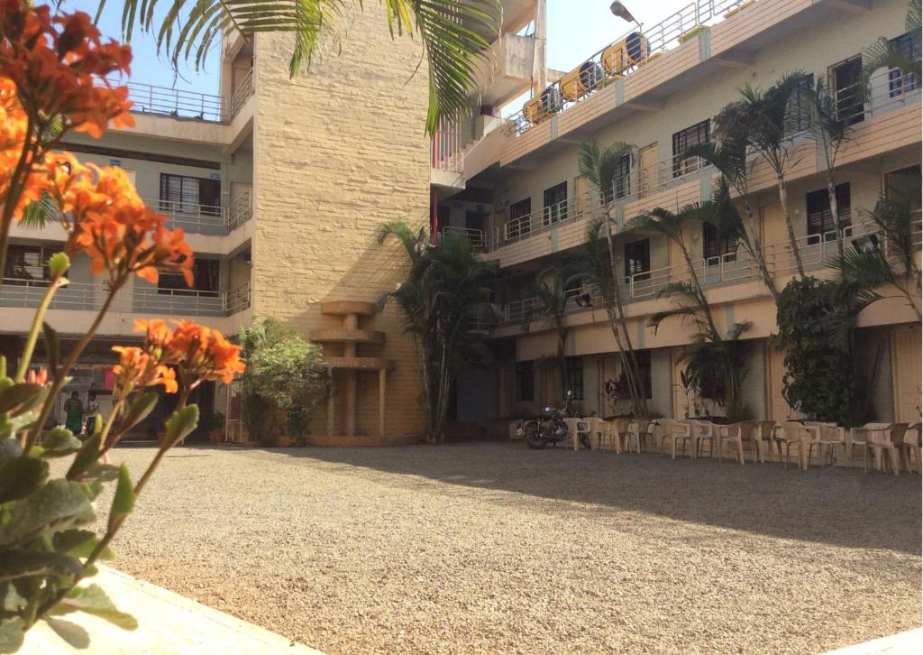 une cour d'un immeuble avec des tables et des chaises dans l'établissement Royale Heritage, à Nashik