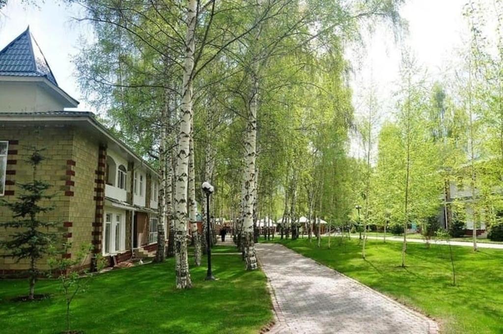 a house with trees in front of a yard at 1 комнатная квартира на Иссык Куле пансионата Радуга in Chon-Sary-Oy