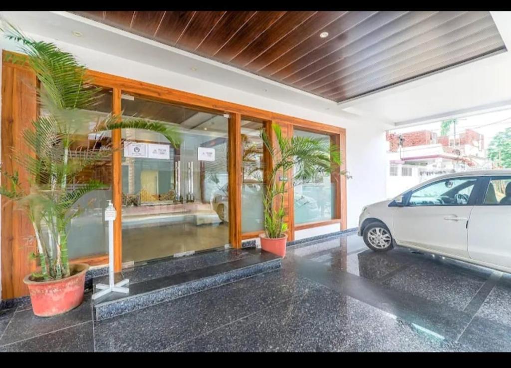 a car parked in front of a building with plants at Hotel Global Inn Glod in Lucknow