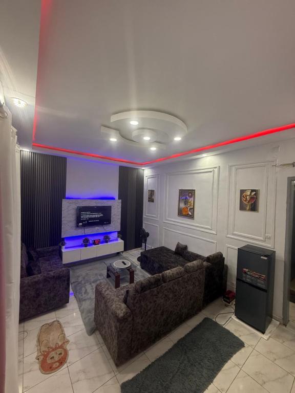 a living room with two couches and a tv at Bon séjour in Bouaké