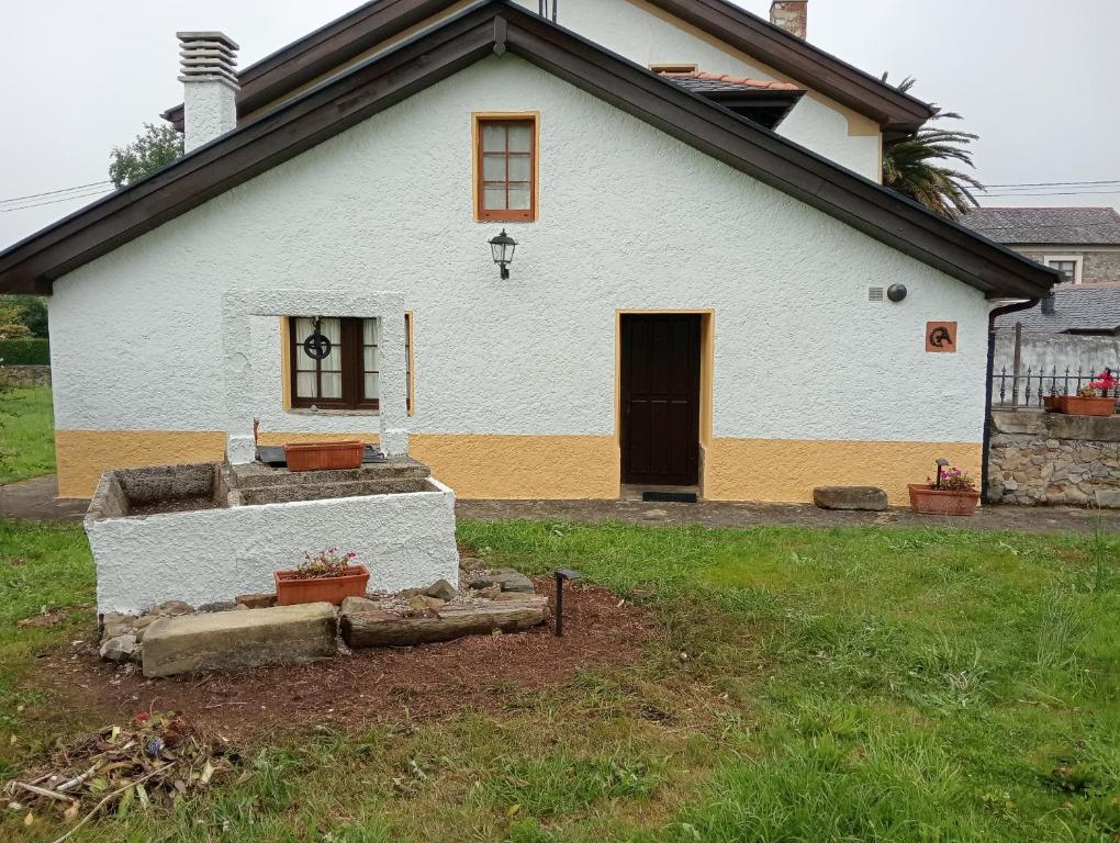 a white house with a door and a yard at Casa De la Agüera in Busto