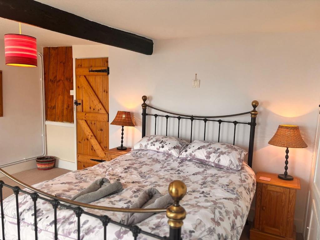 a bedroom with a bed and two lamps and a door at Stunning Jurassic 3 bed with views over Lyme Bay in Lyme Regis