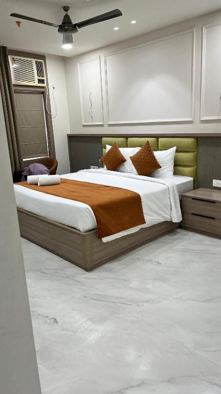 a bedroom with a large bed with brown and white pillows at Bawa Hotel in Jāmb