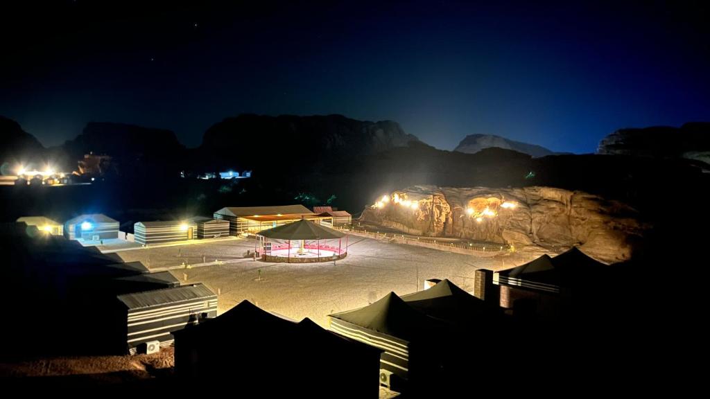 a group of buildings with a rock formation at night at Quiet Night Camp Rum in Wadi Rum