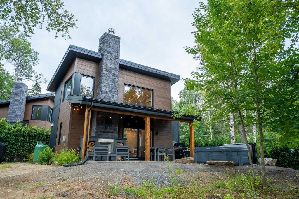 una casa con una chimenea encima en Spa et River - Le Grand-Pic, en Saint-Alexis-des-Monts