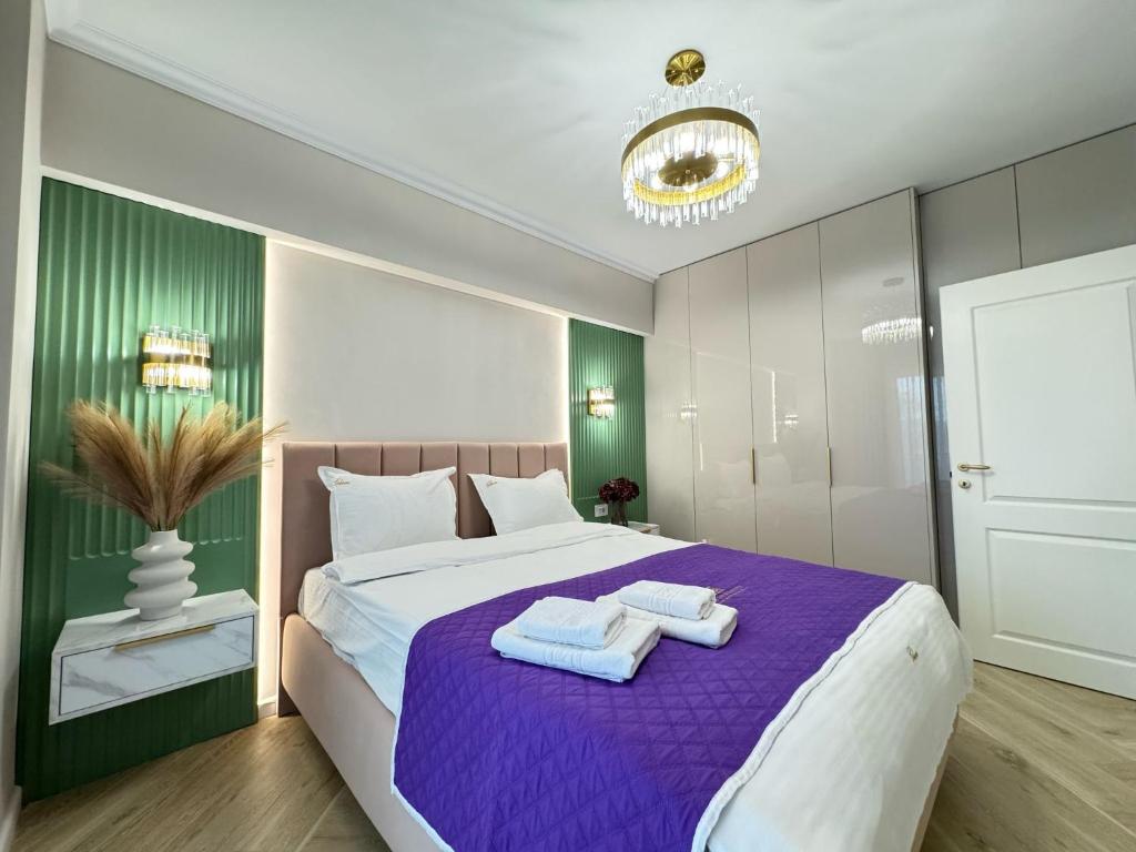 a bedroom with a large bed with towels on it at Iassy Airport Luxury Apartments with Parking in Iaşi