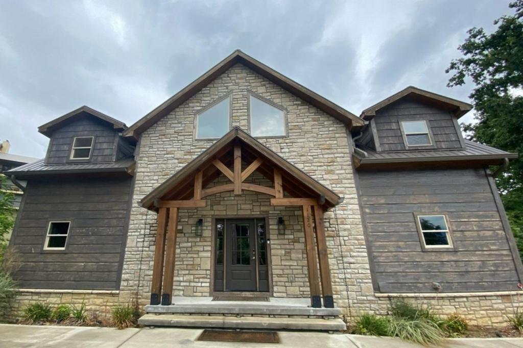 a large brick house with a gambrel roof at The Sundrop - Pool Table, Arcade Games, Outdoor Hot Tub, + Resort Access in Chalet Village