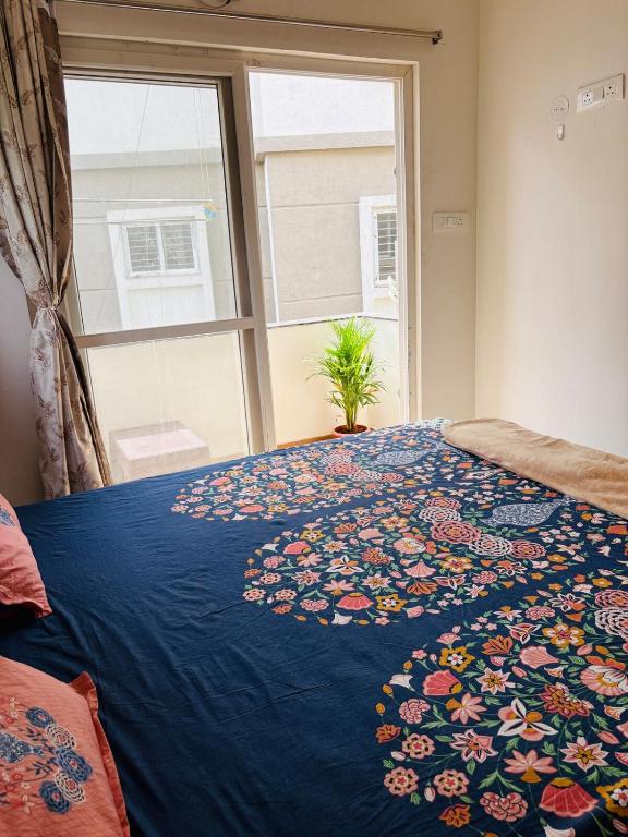 une chambre avec un lit avec une couette bleue et une fenêtre dans l'établissement Holastay, à Jāmb