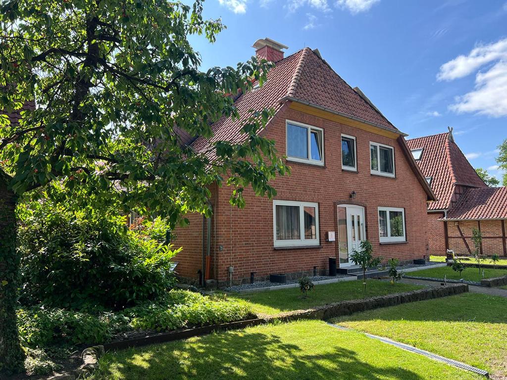 a red brick house with a tree in the yard at Ferienwohnungen Stellichte 