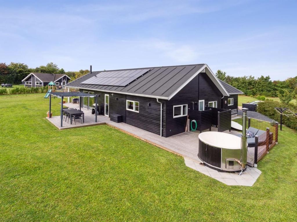 a black house with a gazebo in a yard at Holiday Home Amdi - 700m from the sea by Interhome in Neder Lysabild