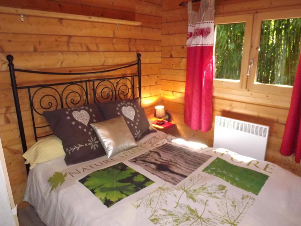 ein Schlafzimmer mit einem Bett in einem Blockhaus in der Unterkunft le chalet in Névy-lès-Dole