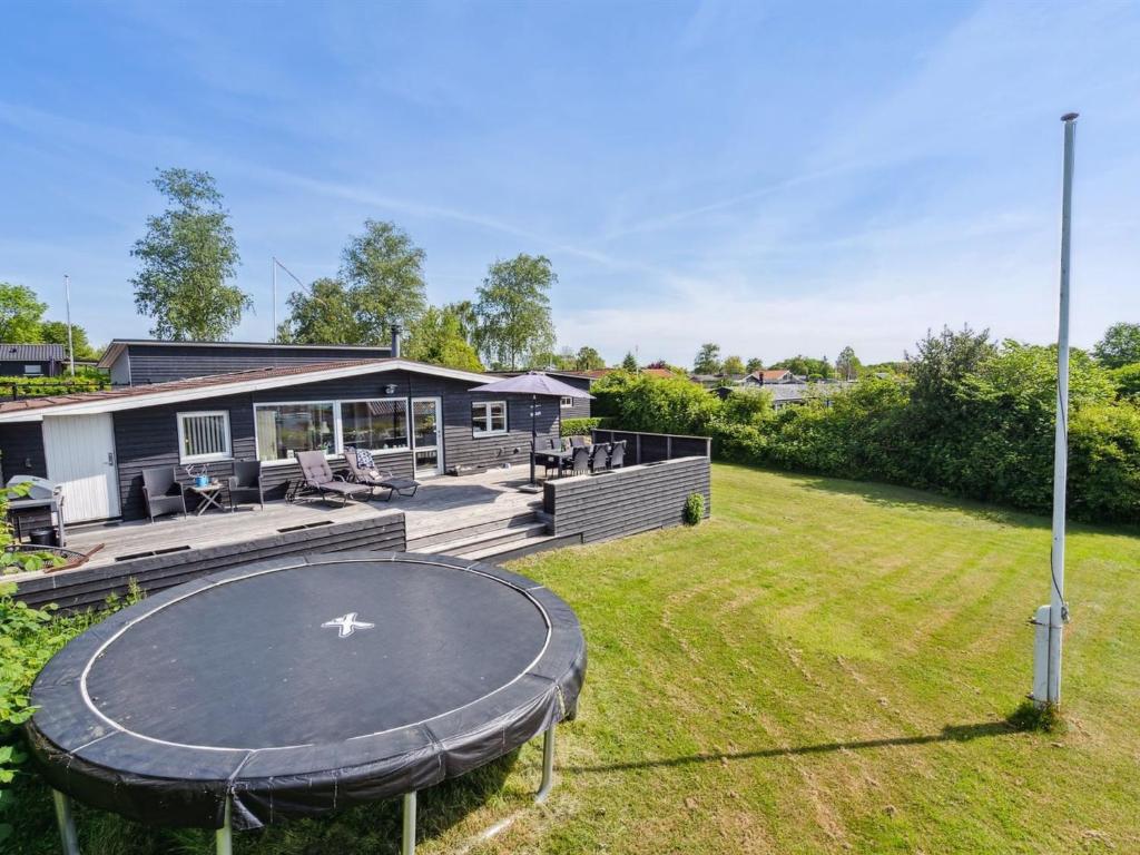 a house with a trampoline in the yard at Holiday Home Thrugils - 200m from the sea by Interhome in Haderslev