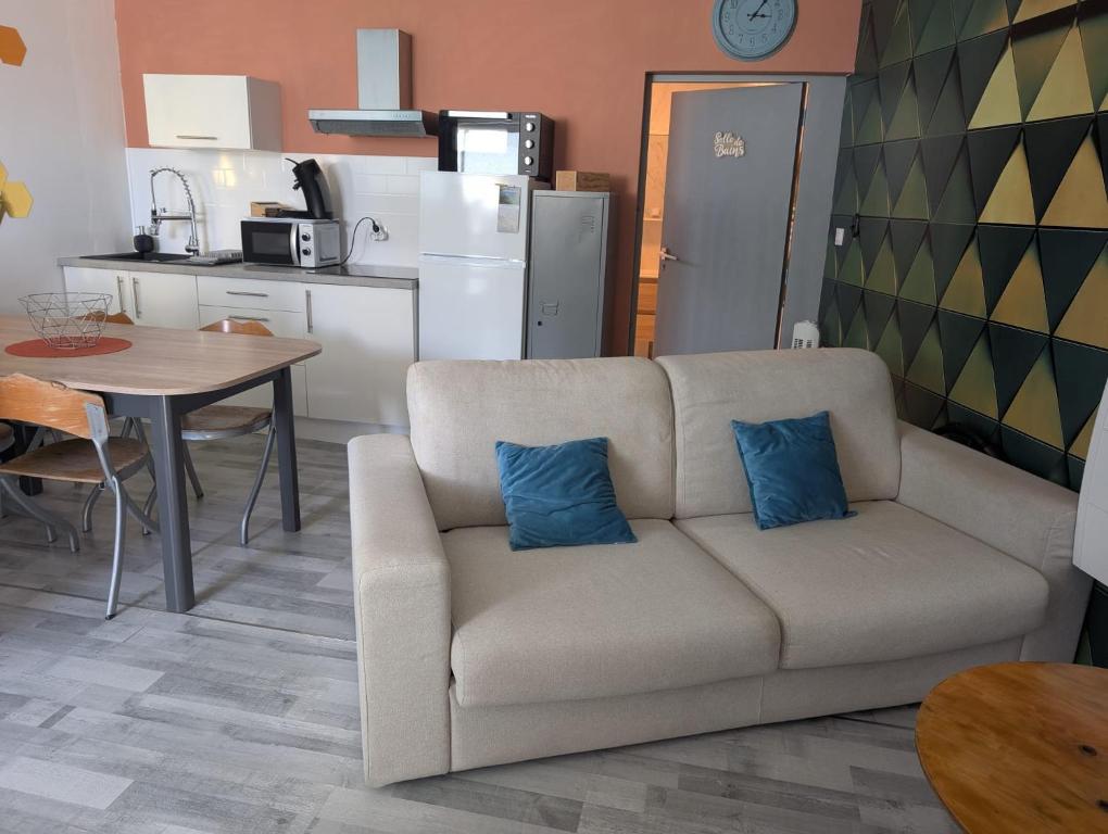 sala de estar con sofá y 2 almohadas azules en L'annexe de l'usine Logement Moderne de campagne, en Saint-Quentin-Lamotte-Croix-au-Bailly