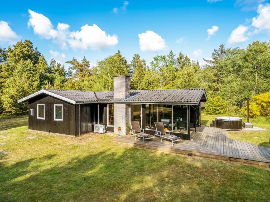 a house with a deck and a backyard at Holiday Home Eli - 1-5km to the fjord by Interhome in Blåvand