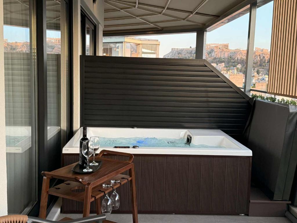 a jacuzzi tub on a balcony with a table at JKB Panoramic Suites in Athens