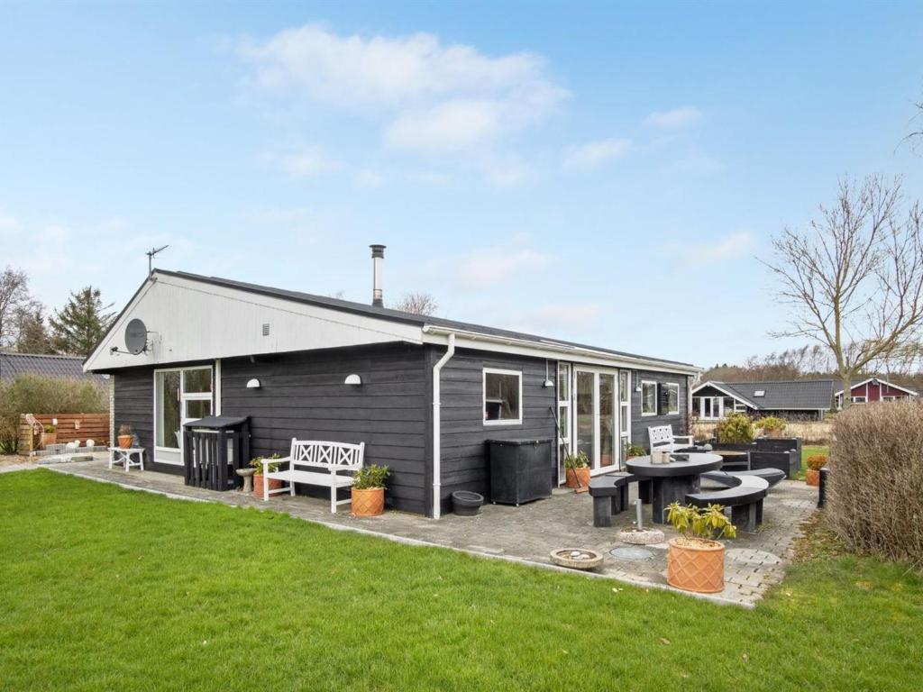 a black house with a patio and a yard at Holiday Home Kjartan - 32m to the fjord by Interhome in Hemmet