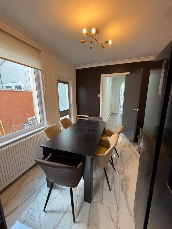 a dining room with a black table and chairs at The Clare Court 6BR Luxury Retreat - Sleeps 14 with Complimentary Access to Billing Aquadrome Holiday Village for Swimming - 2 nights minimum in Kingsthorpe