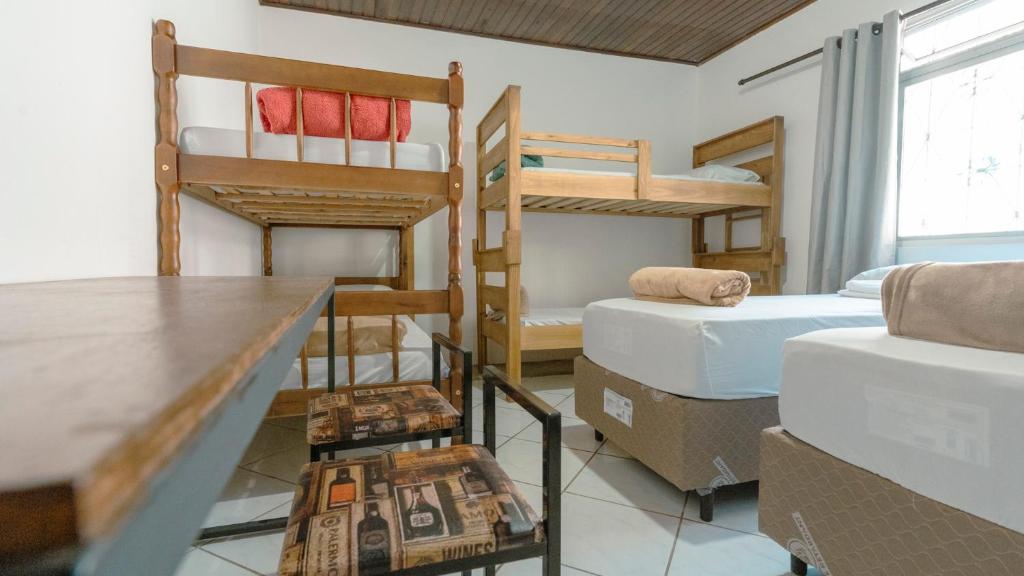 a room with two bunk beds and a table at Smart Hostel - Floripa in Florianópolis