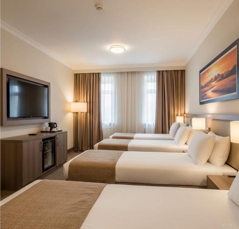 een hotelkamer met twee bedden en een flatscreen-tv bij Baku Khatai Hotel & Restaurant in Baku