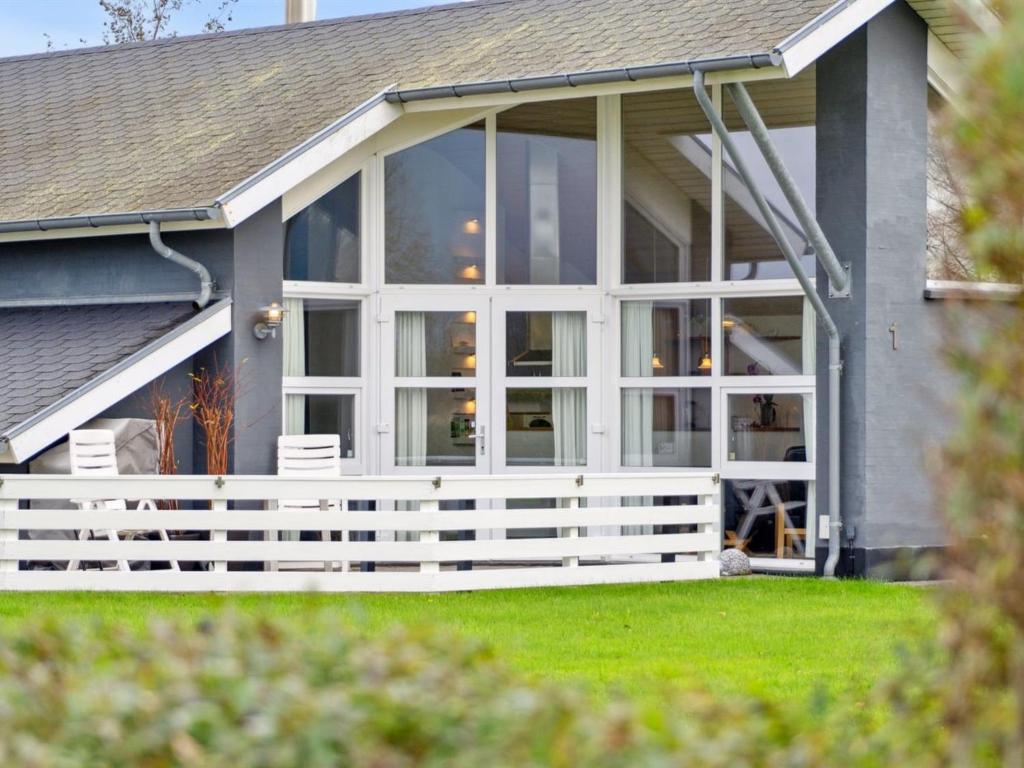a screened porch with white doors on a house at Holiday Home Thrugels - 600m from the sea by Interhome in Hadsund