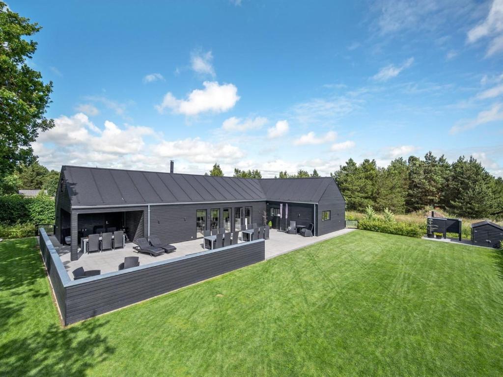a large black house with a large yard at Holiday Home Henrikke - 500m to the fjord by Interhome in Skjern