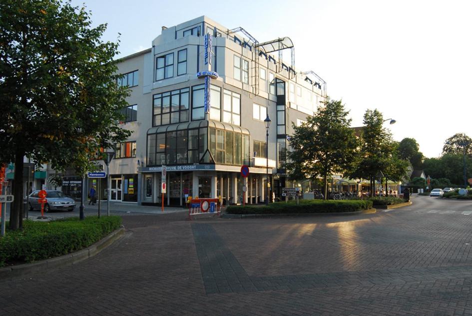 een groot gebouw aan een stadsstraat met een weg bij Hotel De Swaen in Herentals
