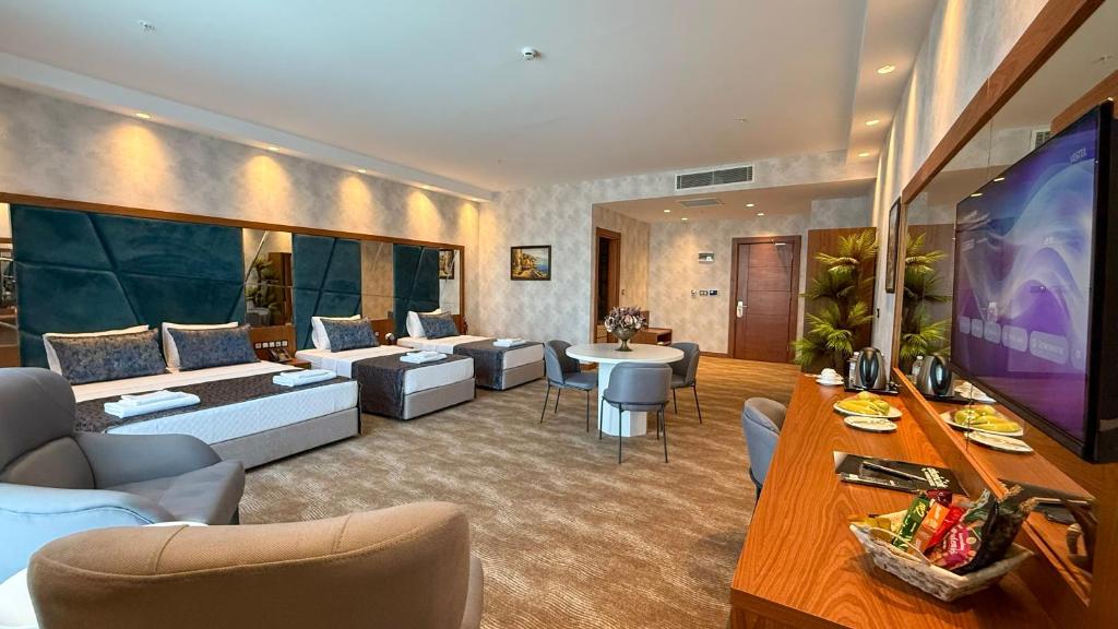 a large living room with a large screen tv at Alsancak Prime Hotel Konya in Yazır