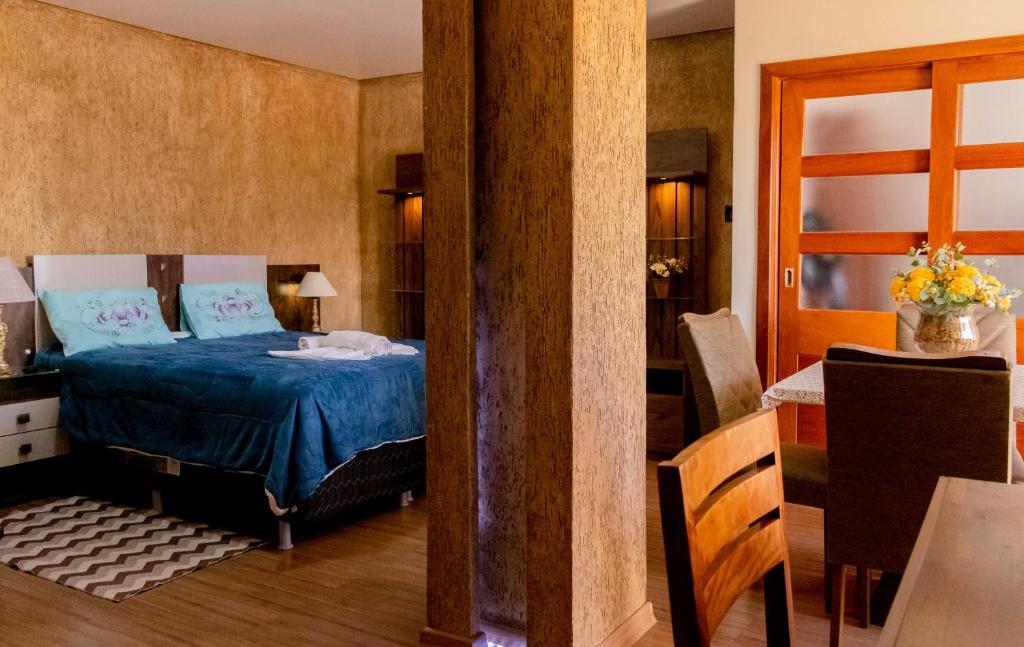 a bedroom with a blue bed in a room at Apart Hotel Caminho do Trem in São João del Rei