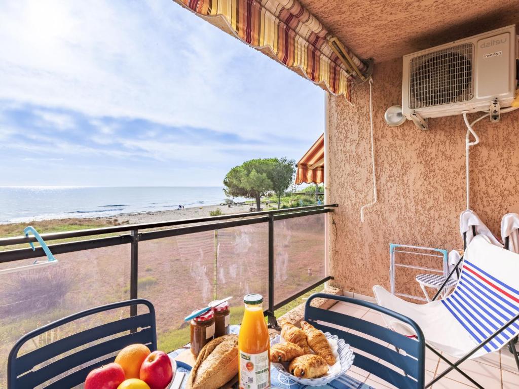 einen Tisch mit Speisen auf einem Balkon mit Meerblick in der Unterkunft Studio Marines de Moriani by Interhome in Moriani Plage