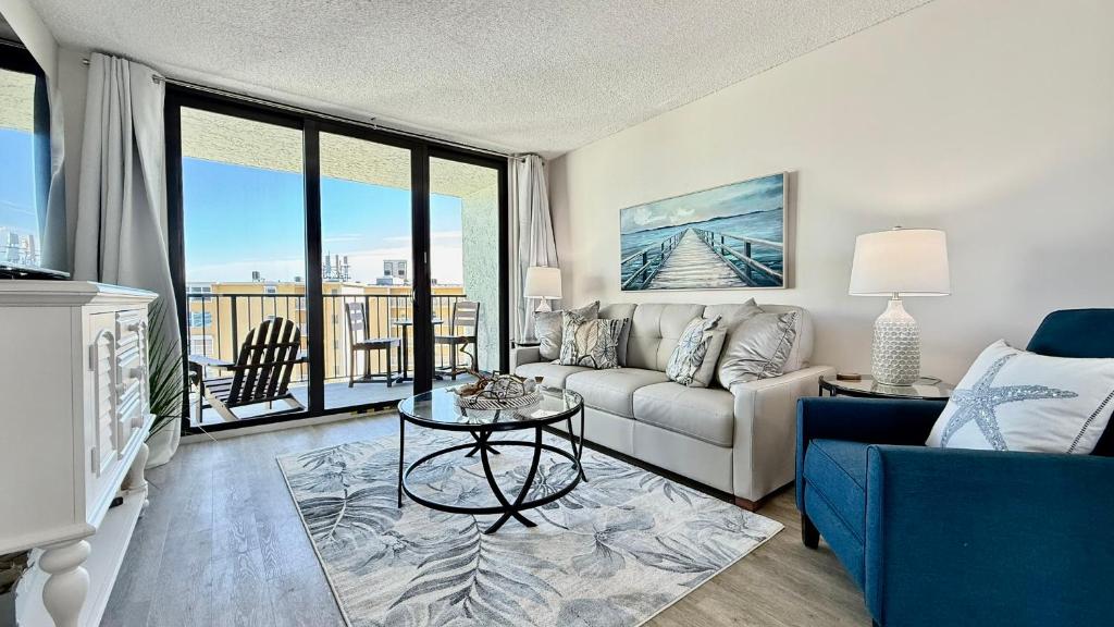 a living room with a couch and a table at Top-floor ocean view condo with a private balcony and beachfront pool in Edgewater