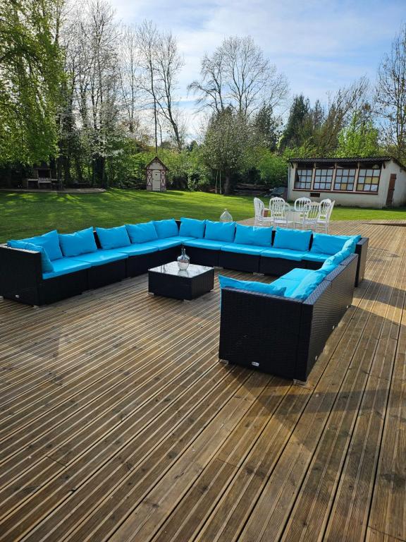 un sofá azul sentado en la parte superior de una terraza de madera en Le clos des oiseaux, en Maisnières