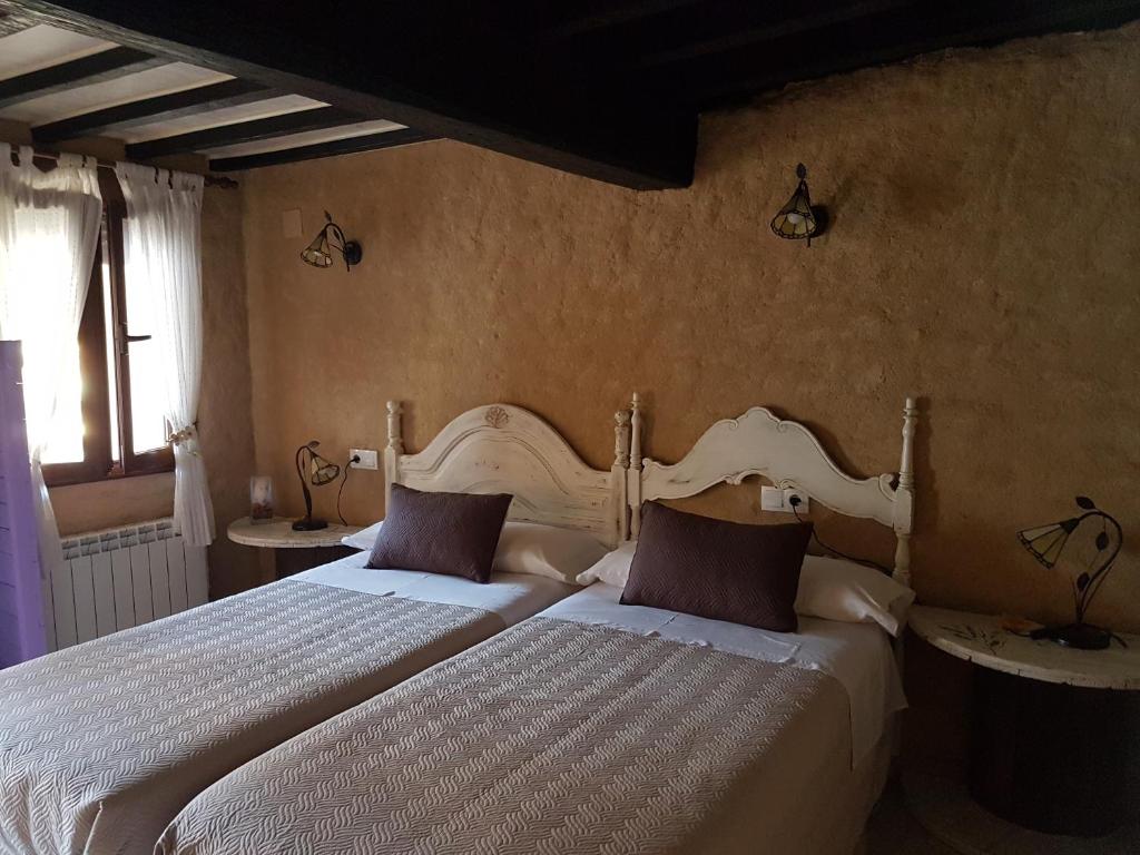 1 dormitorio con 2 camas y 2 lámparas en Casa Angel, en Sequeros