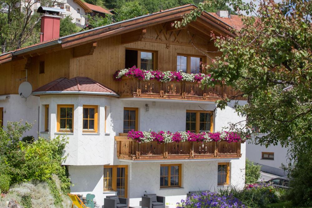 a building with a balcony with flowers on it at Apart Röck in Ladis