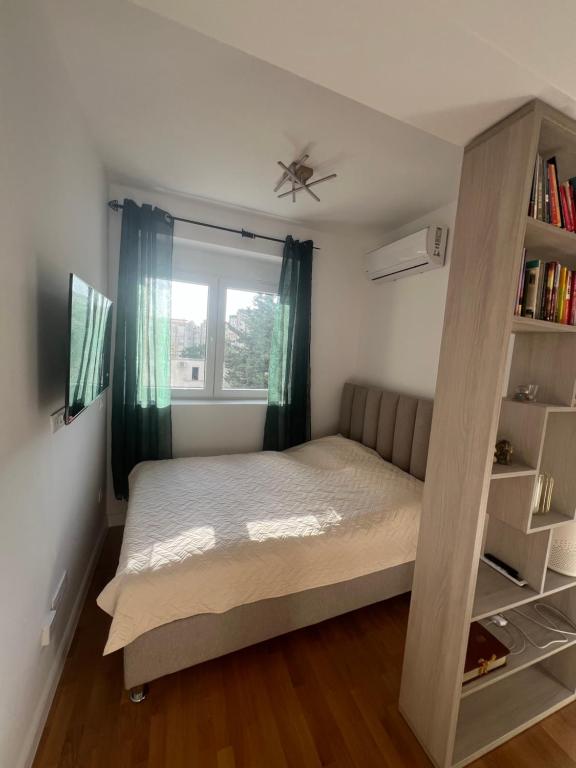 a bedroom with a bed and a book shelf at SunnyBar in Bar