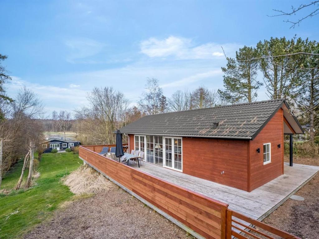 a small house with a large wooden deck at Holiday Home Preben - 50m from the sea by Interhome in Stege