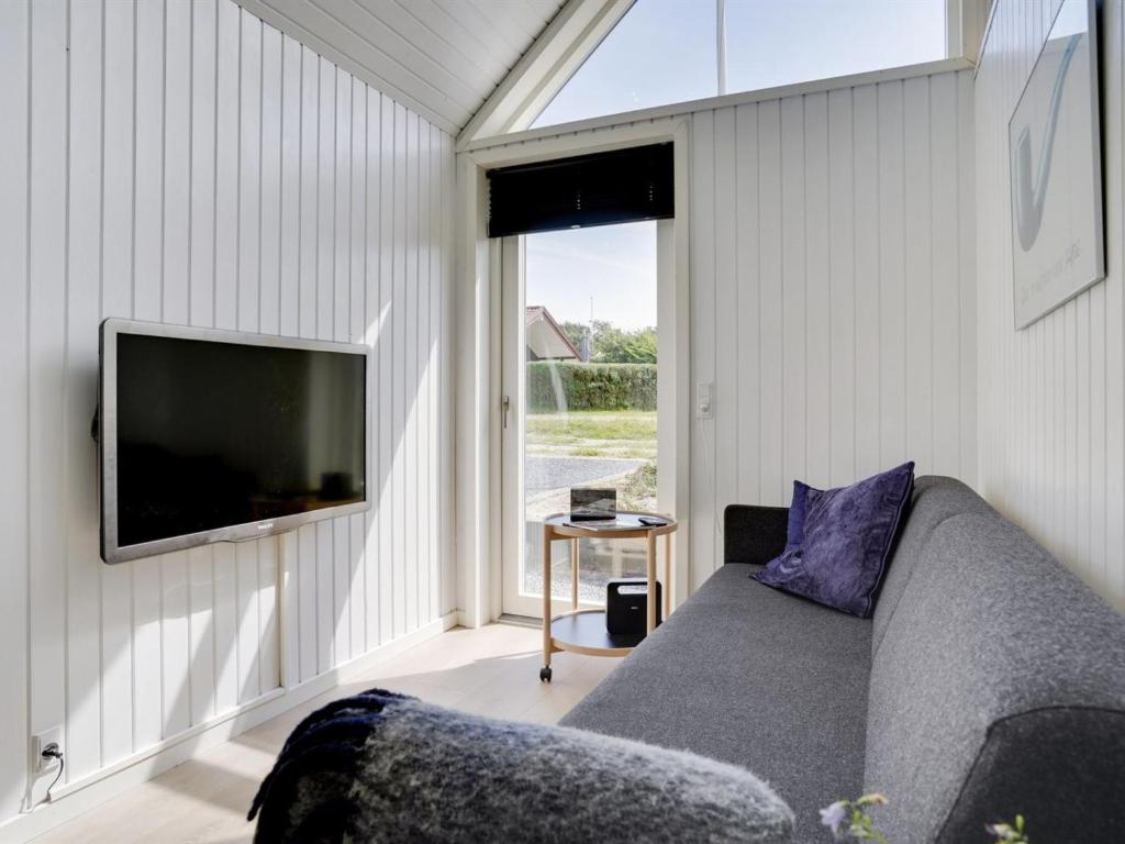een woonkamer met een bank en een flatscreen-tv bij Holiday Home Solfrid - 150m from the sea by Interhome in Esbjerg