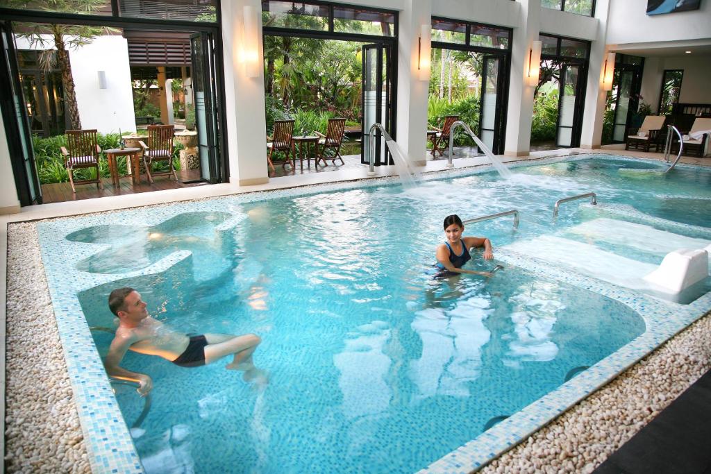 An indoor-outdoor hydrotherapy-style pool with built-in seating and jets.