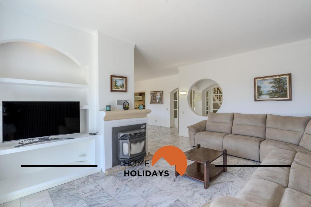 a living room with a couch and a fireplace at #336 Vila Sol by Home Holidays in Sesmarias