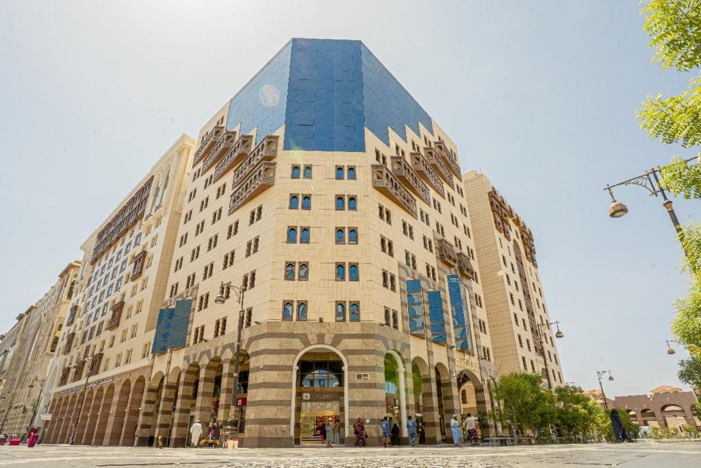 a large building with people standing in front of it at فندق رؤى الاندلس البلاتيني - Roaa Alandalus Platinum Hotel in Medina