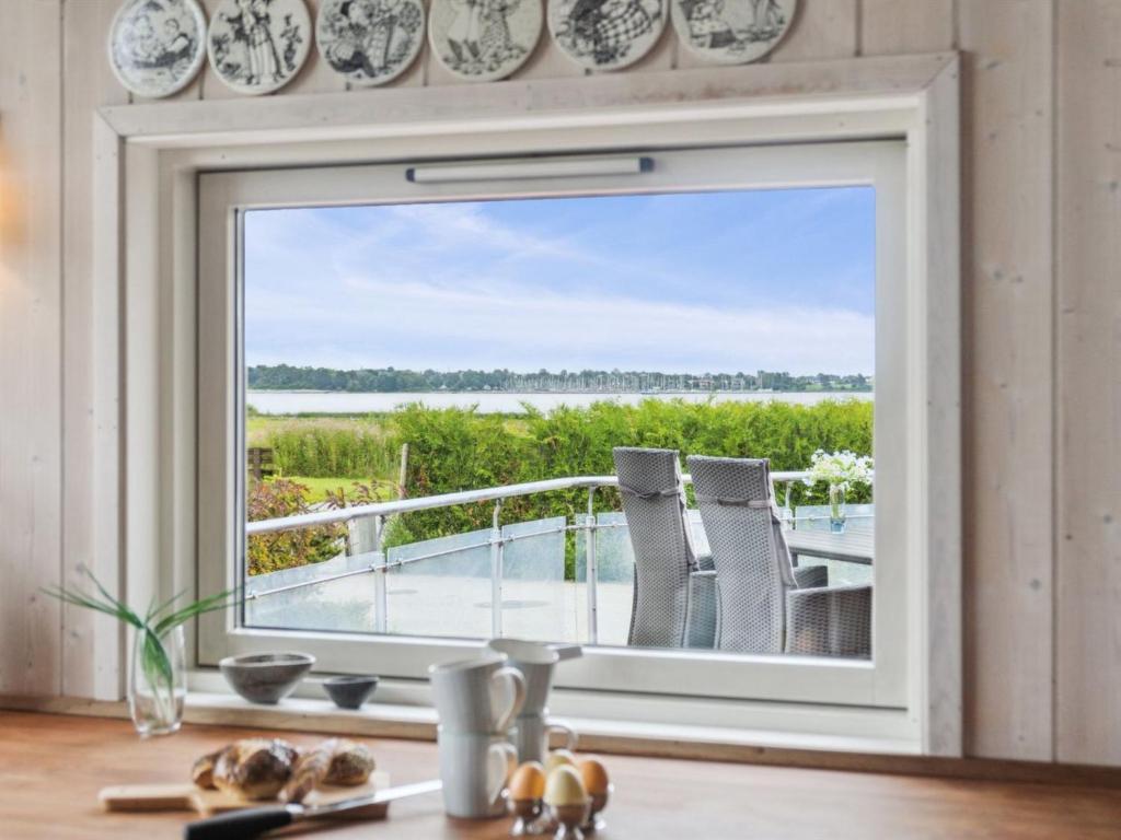 een raam in een keuken met uitzicht op de oceaan bij Holiday Home Annrike - 175m to the inlet by Interhome in Jægerspris