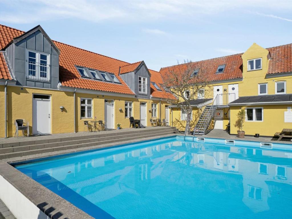 a swimming pool in front of some buildings at Apartment Merta - 500m from the sea by Interhome in Gudhjem