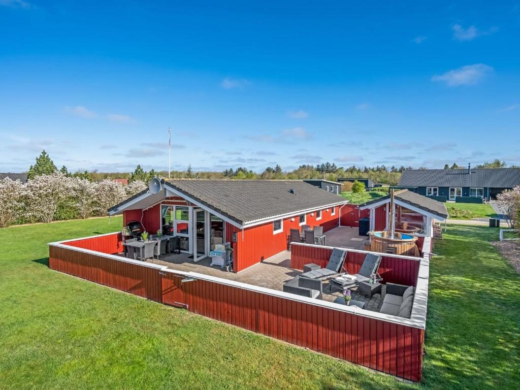 an orange house with a red fence in a yard at Holiday Home Seba - 1km to the fjord by Interhome in Hemmet