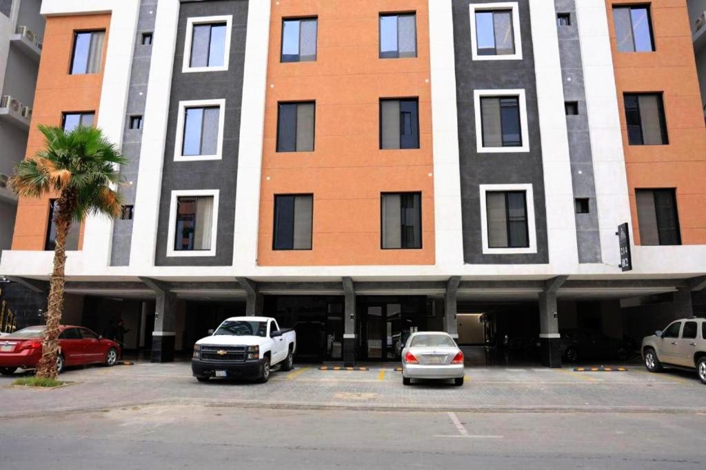a large building with cars parked in a parking lot at شقة الزمرد in Jeddah