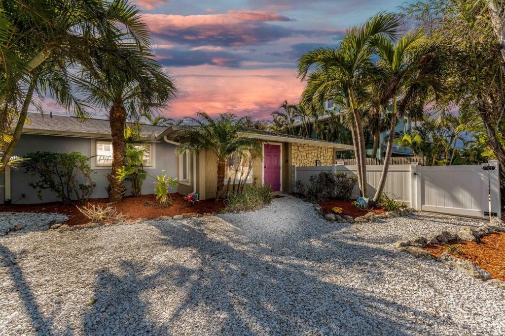 a house with palm trees in front of a driveway at Ocean72 Holmes Beach Vacation Home with Private Pool & hot tub & Walk-to-Beach Access in Holmes Beach