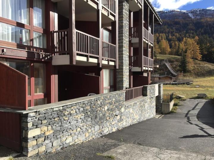 a building with balconies and a stone retaining wall at Ski en 5 secondes! in Val Cenis