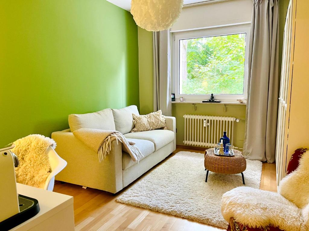 ein Wohnzimmer mit einer Couch und einem Fenster in der Unterkunft Ruhiges Messezimmer im Diplomatenviertel mit Grünblick in Niederdorla