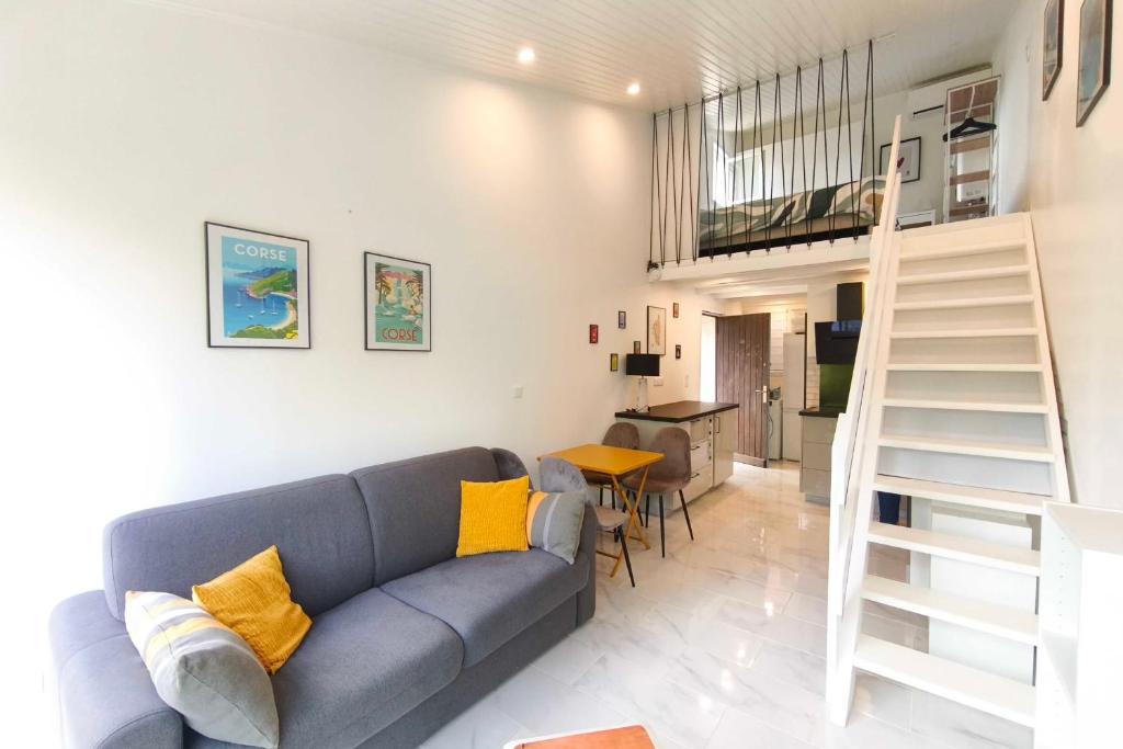 a living room with a blue couch and a staircase at Studio with sea view in Orcino
