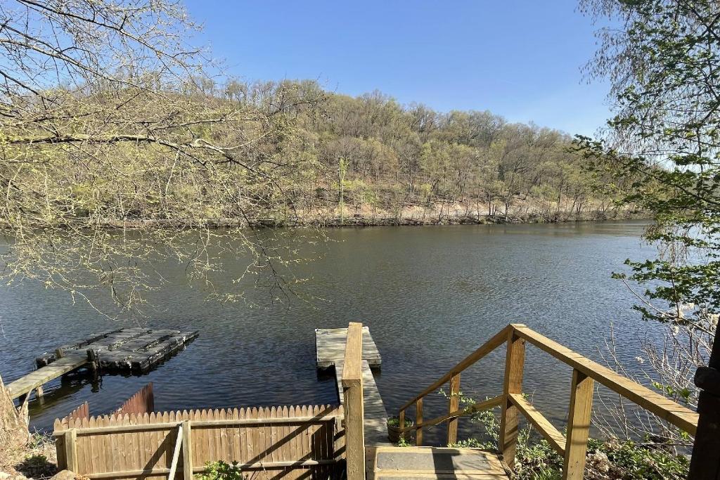 a view of a river with a wooden dock at Lake Zoar Cabin in Newtown